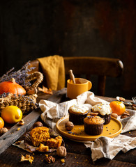 homemade tasty sweet orange pumpkin muffins or cupcakes with white cream, lavender, zest, nuts