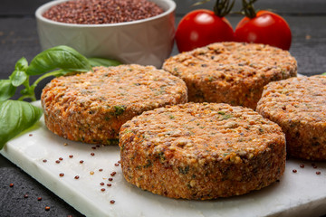 Fototapeta na wymiar Tasty vegetarian burgers made from healthy quinoa, basil, tomatoes and mozzarella cheese
