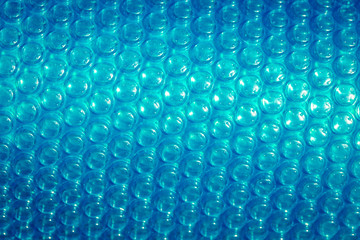 Plastic blue bubble wrap texture background, close up.