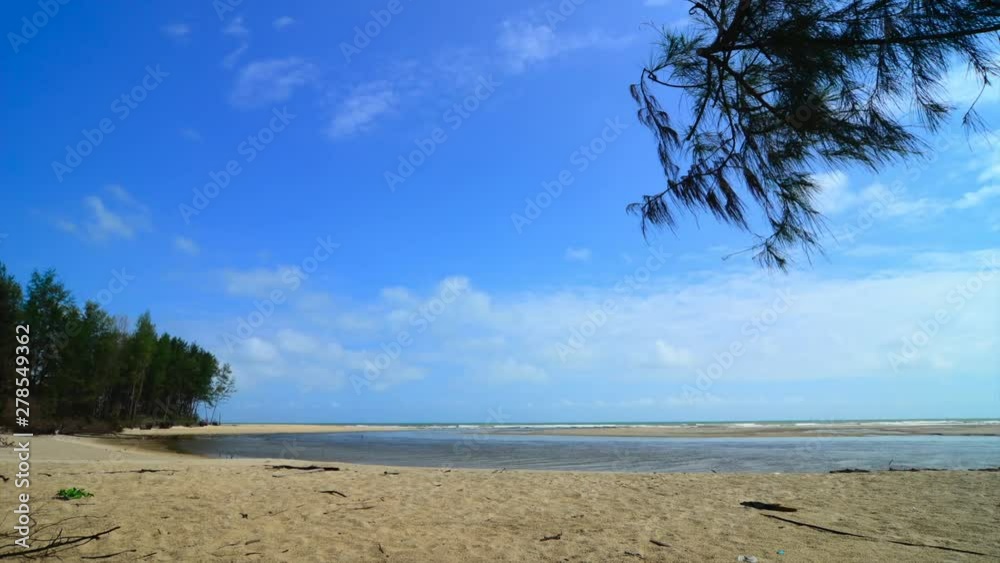 Wall mural footage of tropical seascape under bright sunny day and blue sky background. wave hitting the shorel