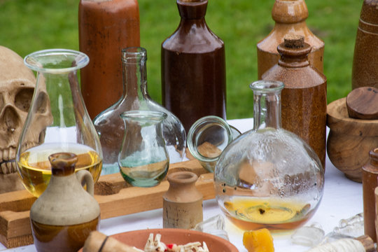 Table of medieval apothecary with bottles and jars