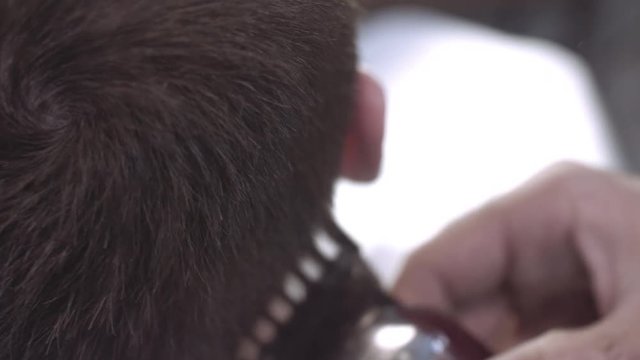 Close-up of an unidentified barber straightens a man client's hair