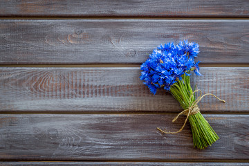 Summer flowers pattern with bouquet of blue cornflowers on wooden background top view mock up