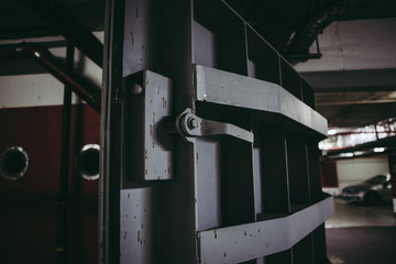 Details with the heavy metal doors of a nuclear explosion shelter (fallout shelter), four stories below ground in a deep underground parking place.