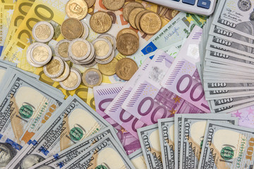 Euro and dollar banknotes as background for coins and calculator