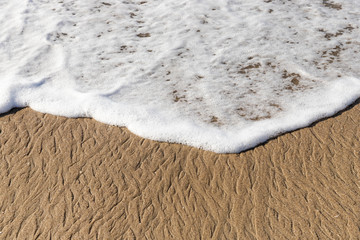 Espuma da onda a beira mar