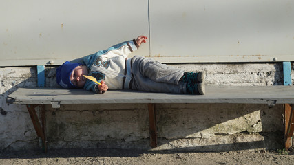 Cute little boy lying on the bench outdoors