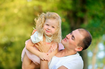 people concept. Friendly family in a beautiful summer park. dad playing with fun little daughter