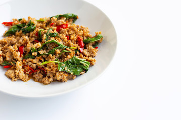 Stir-fried hot and spicy pork with holy basil on white.