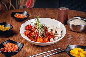Flat lay korean traditional food with kimchi on wooden background. Korean noodles with onions, red sauce and sesame, chicken meat. Traditional asian cuisine. Lunch. Healthy food