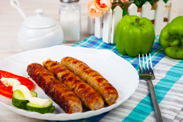 Kupaty in a white plate and vegetables