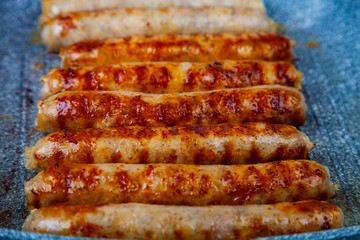 Kupaty in a frying pan on a wooden table.