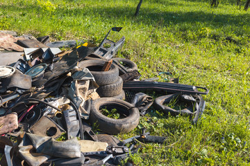 A pile of garbage auto parts in the forest.