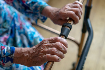 Close-up of senior woman moving with the help of walker. Old sick woman 90 years in the hospital