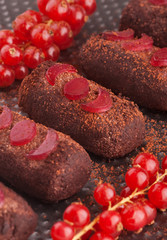 Rum chocolate balls with cocoa powder on a tray and red currant