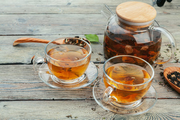 Cup of tea and tea leaves on wooden table