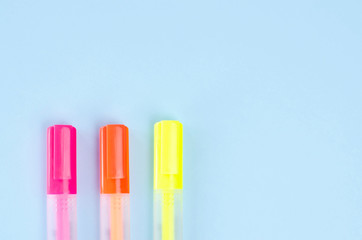 Three neon markers on a blue background.