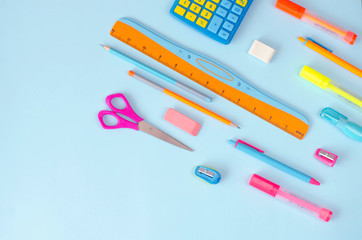 Flat lay from a variety of stationery on a blue background.