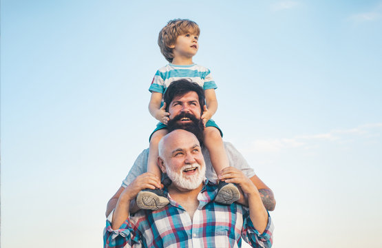 Men generation: grandfather father and grandson are hugging looking at camera and smiling. Fathers day concept. Generation concept. Weekend family play. Men in different ages.