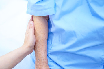 Caregiver holding hands Asian elderly woman patient with love, care, encourage and empathy at...