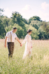 Fototapeta na wymiar Newlywed Couple Walking Holding Hand