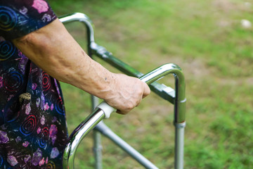 Asian senior or elderly old lady woman patient walk with walker in park : healthy strong medical concept 
