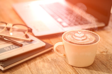 Office table with notebook and cup of coffee