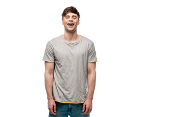 cheerful young man in grey t-shirt smiling at camera isolated on white