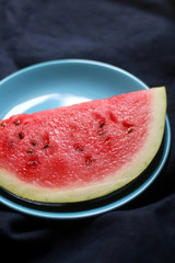 Slice of watermelon on turquoise plate. Selective focus.