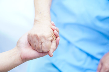 Caregiver holding hands Asian elderly woman patient with love, care, encourage and empathy at...