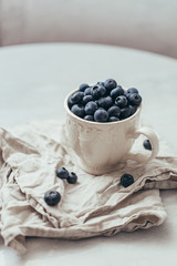 Blueberry in a old rustic style mug on white background