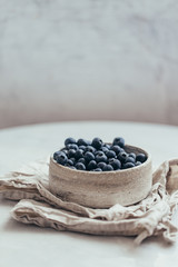 Fototapeta na wymiar Blueberry bowl on white background with copy space in rustic style