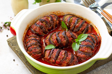 Thanksgiving day food concept. Homemade Baked eggplants close-up, stuffed with turkey meat in tomato sauce on stone table.