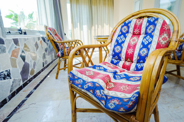 Rattan chairs with soft cushions with oriental pattern.