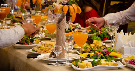 Restaurant vintage, cutlery, glasses on the table, bar, bottles, large candles on a white tablecloth, sliced fruit with powdered sugar