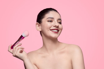 Smiling model with makeup brush