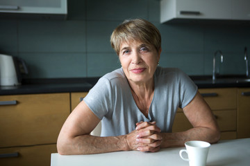 Portret happy senior woman  in kitchen is looking at camera. positive. happy lifestyle concept