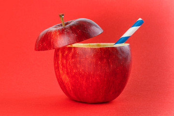 Health Red Cut Apple recyclable paper straw juice drink idea concept on red background