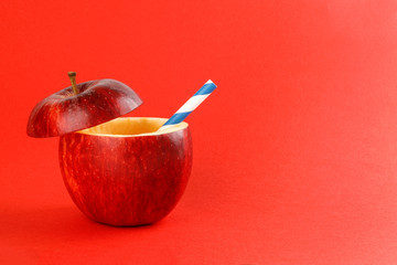 Health Red Cut Apple recyclable paper straw juice drink idea concept on red background