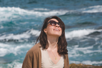 woman at sea beach enjoying power of nature. windy weather