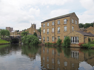 Fototapeta na wymiar a scenic view of the town of sowerby bridge in west yorkshire with buildings reflected in the canal basin and buildings behingd the lock gates