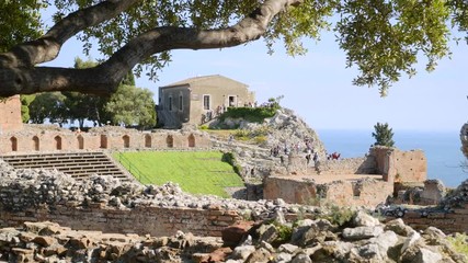 Mass tourism in the ancient Greek amphitheater, Taormina, Ionian Sea view
