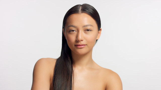 straight crop head and shoulders mixed race asian model in studio on white with ideal glowy skin natural makeup
