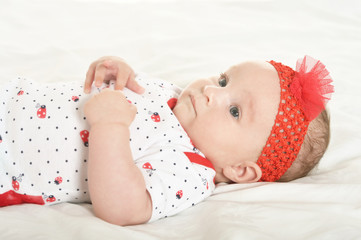 Portrait of cute baby girl on white blanket