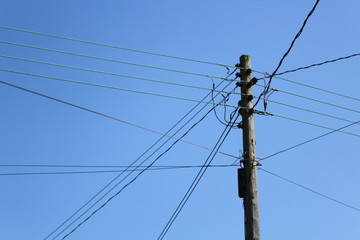 Old power telephone pole and wires blue sky