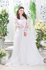 Portrait of young beautiful bride in white dress posing