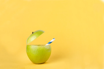 ealthy Green Cut Apple recyclable paper straw juice drink idea concept on yellow background