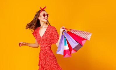 concept of shopping purchases and sales of happy   girl with packages  on yellow background