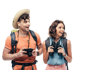 two excited young tourists with digital camera and binoculars looking away isolated on white