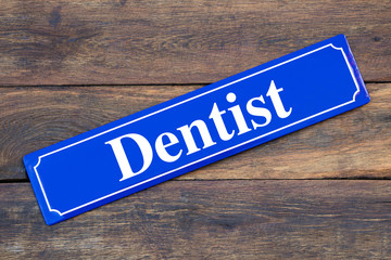 Dentist aid street sign on wooden background